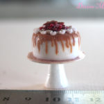 deliciously decadent berry topped, salted caramel drizzle, cinnamon iced cake on a stand in 1:12 scale dollhouse miniature